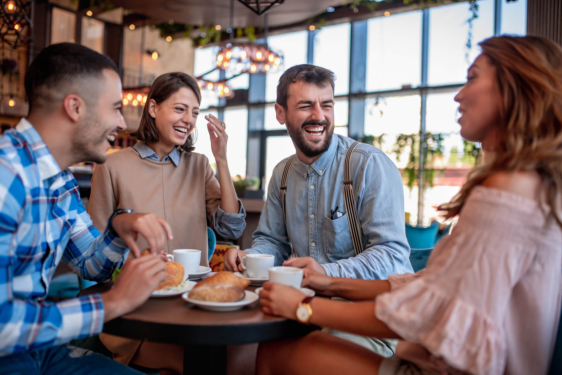 Young friends having a great time in restaurant. Group of young people sitting in a coffee shop ,drinking coffee.